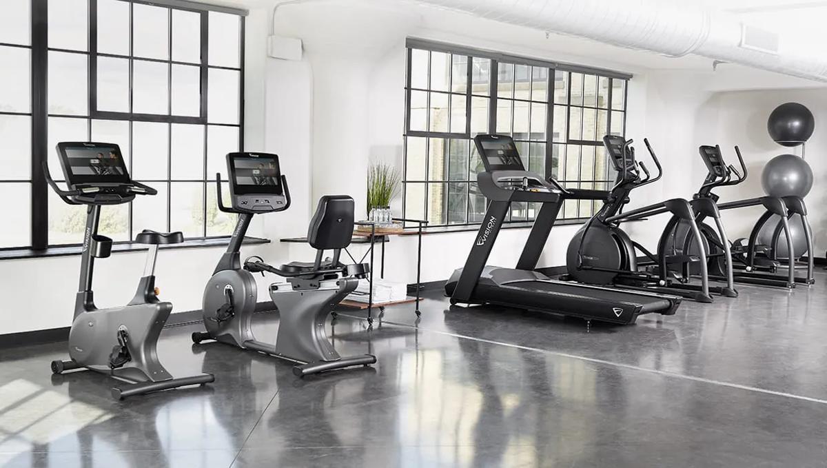 Lineup of Vision Fitness commercial cardio equipment in a sunlit gym